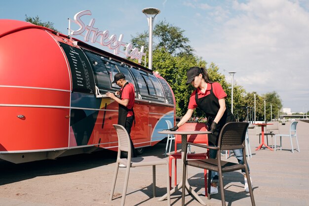 young-female-clerk-food-truck-cleaning-table_274679-28919